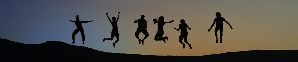 Friends jumping against a desert sunset